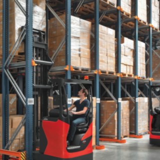 Two Linde reach trucks in use on a rack.