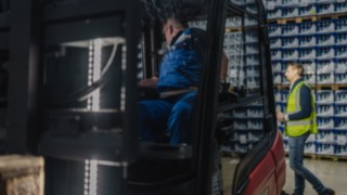 A driver is reversing in a Linde X30 electric forklift truck towards a person, which is detected by the Reverse Assist Radar.