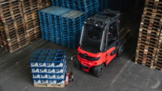 The Linde electric forklift truck X30 reversing out of an aisle straight towards an obstacle of drink crates.