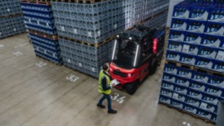 The Linde X30 electric forklift truck is reversing out of an aisle, with a pedestrian in the way.