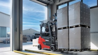 Linde Material Handling Xi20 PH electric forklift truck transporting goods from the warehouse to the outside area.