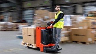 A Linde T20 pallet truck driving through a warehouse; the driver is in a 45-degree position